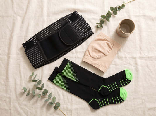 A pregnancy support belt, a seamless belly band and compression socks laid flat