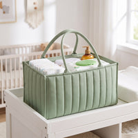 Sage green Bumpwell diaper caddy on a changing table, filled with diapers and wipes