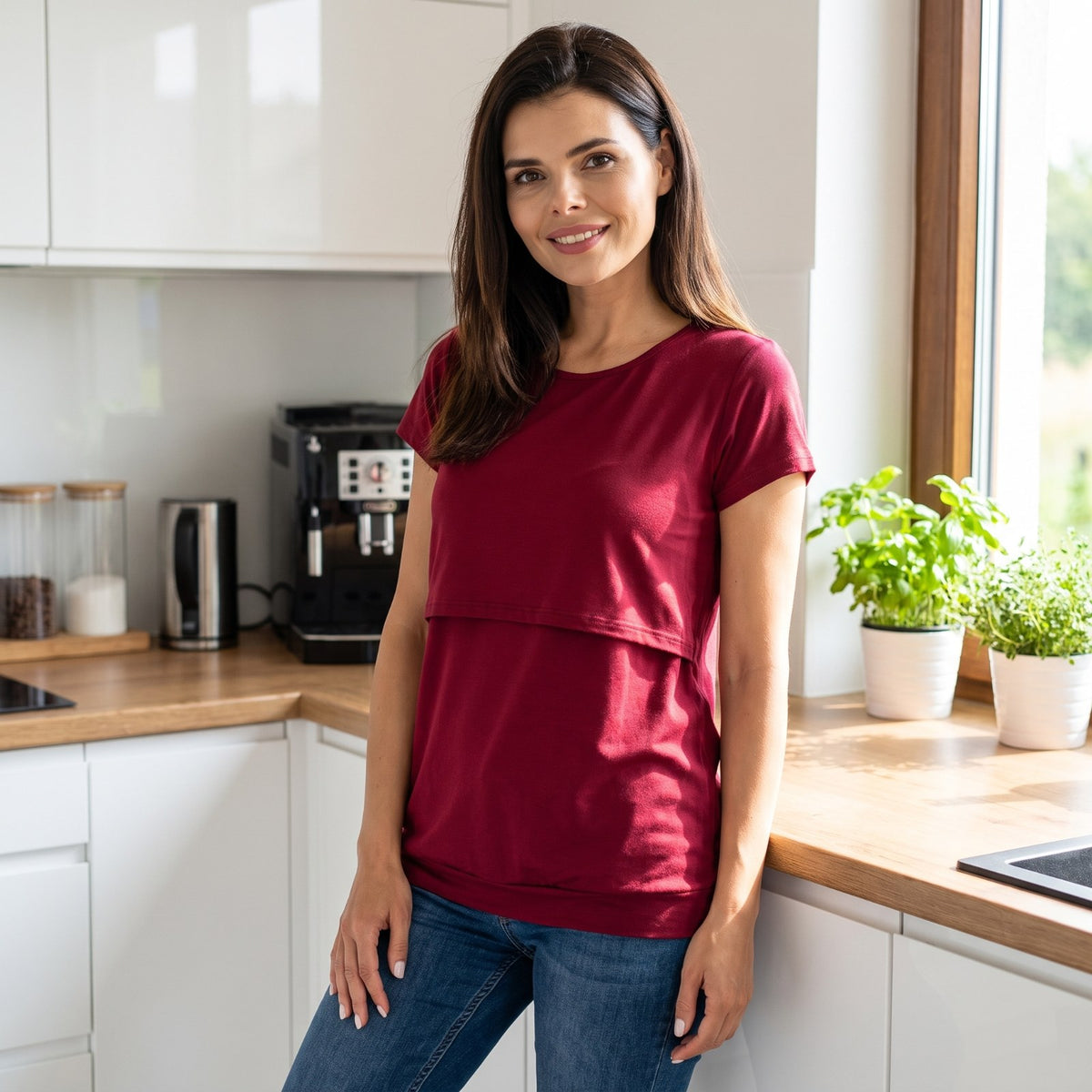 Woman in a kitchen wearing the burgundy Bumpwell nursing T-shirt