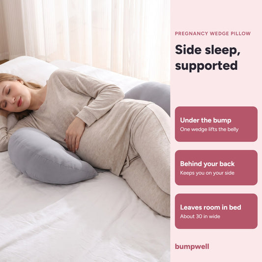 Pregnant woman sleeping on her side with the grey Bumpwell pregnancy wedge pillow under her bump and behind her back