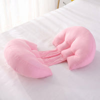 Pink Bumpwell pregnancy wedge pillow on a bed