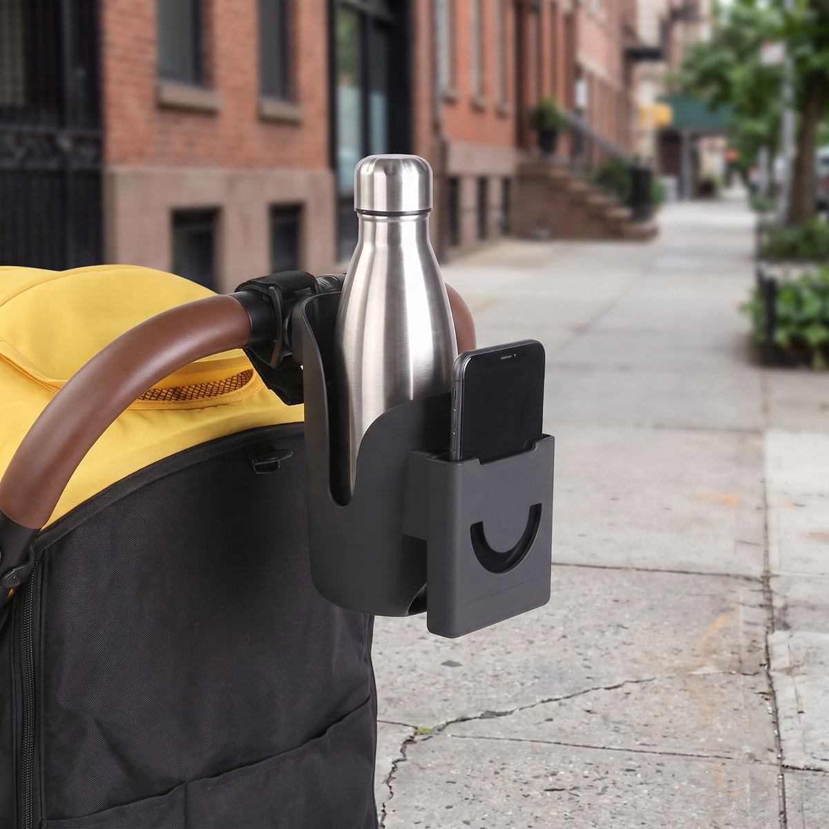 Bumpwell stroller cup holder carrying a water bottle and a phone on a city walk