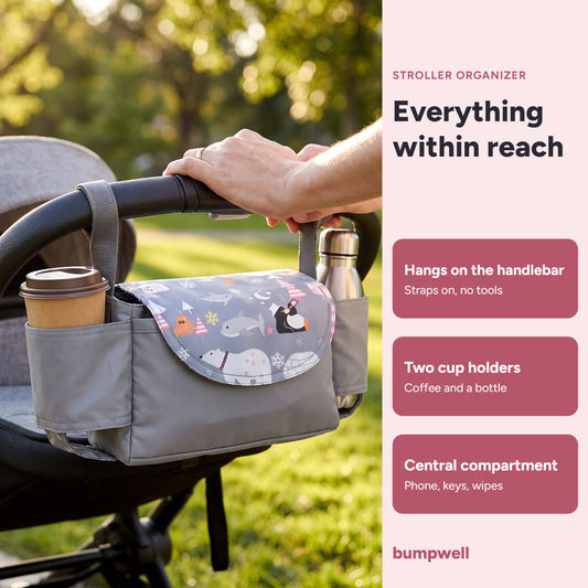 Bumpwell stroller organizer on a handlebar holding a coffee cup, with two cup holders and a central compartment