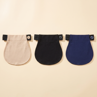 Three maternity pants extenders in beige, black and navy on a cream background