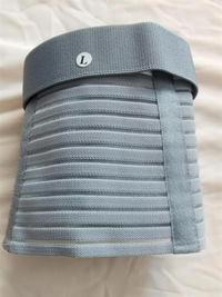 Grey pregnancy support belt folded flat, showing the wide back panel