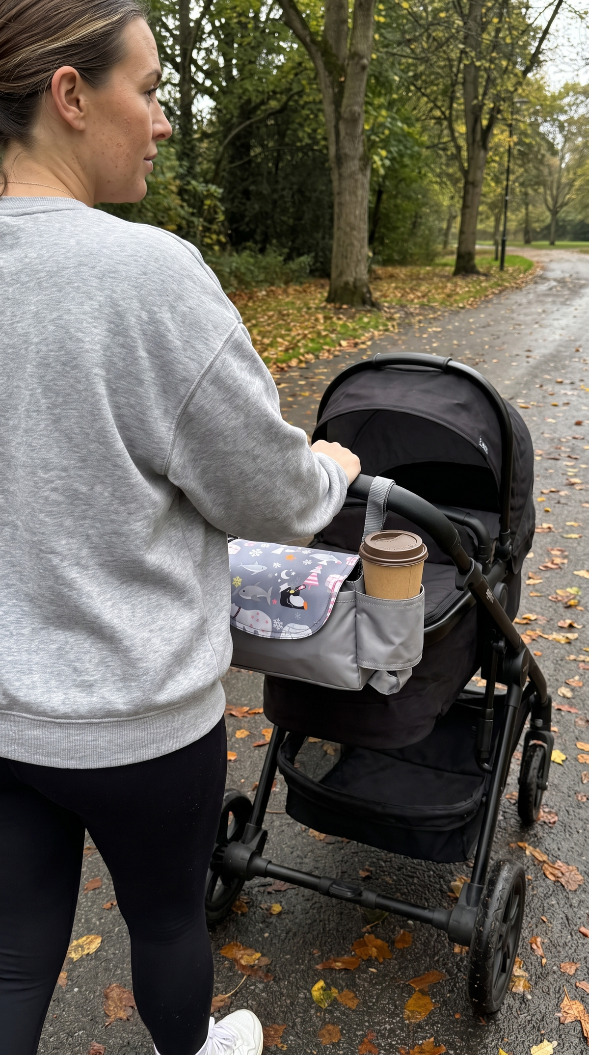 Bumpwell stroller organizer on a stroller handlebar with a coffee cup in the holder