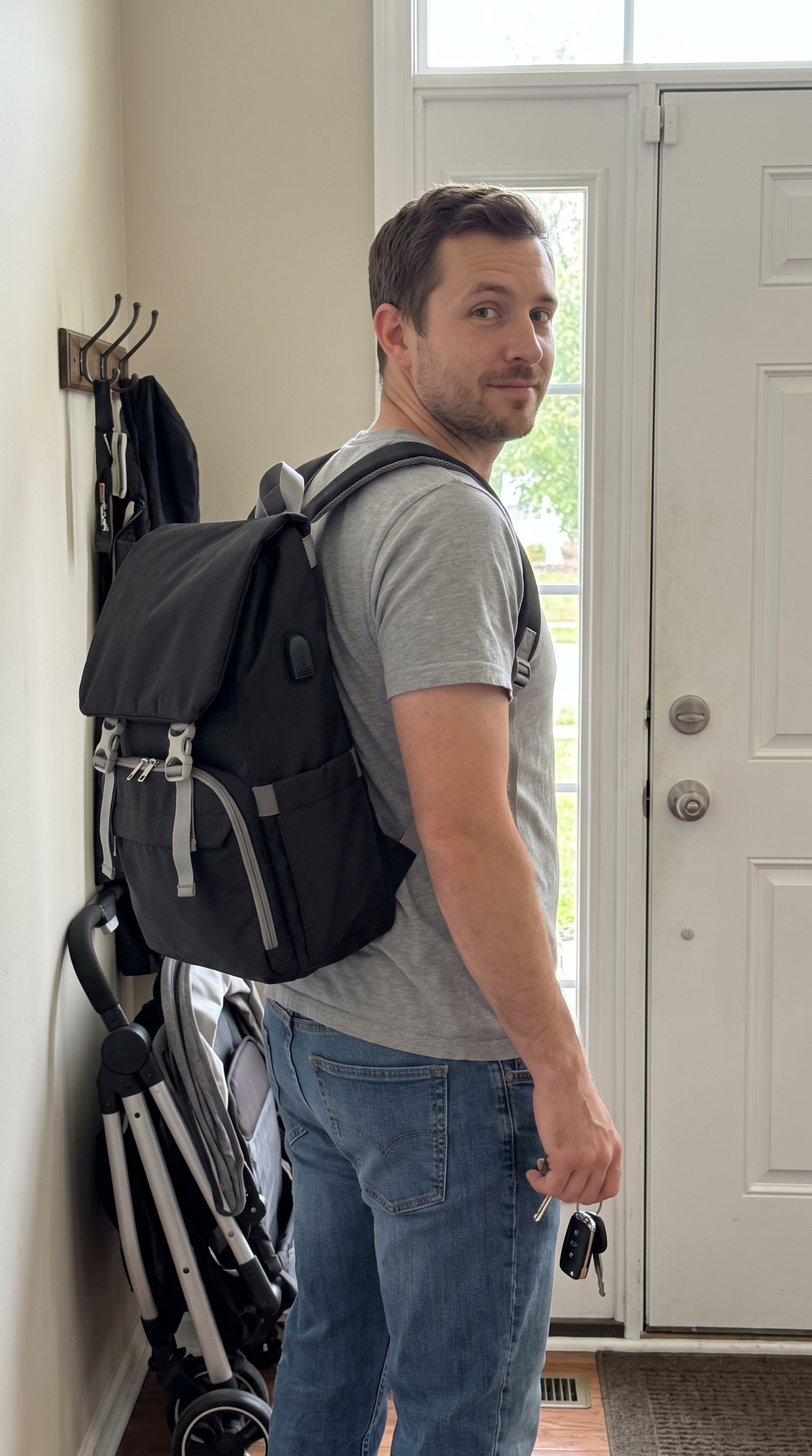 Man wearing the Bumpwell dad diaper backpack by the front door