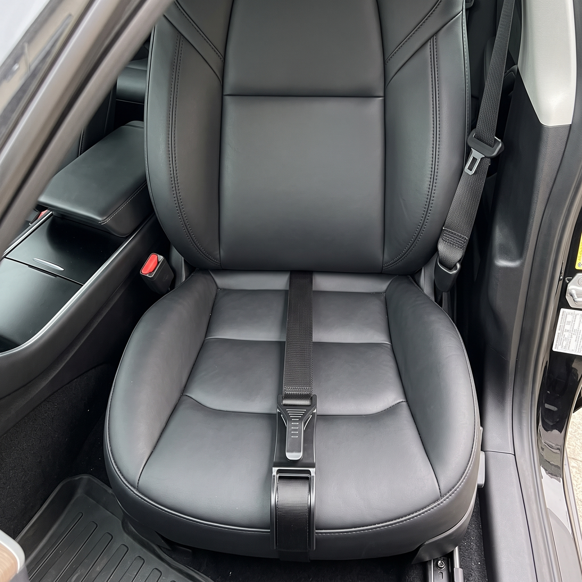 Seat belt adjuster installed on the front edge of a car seat